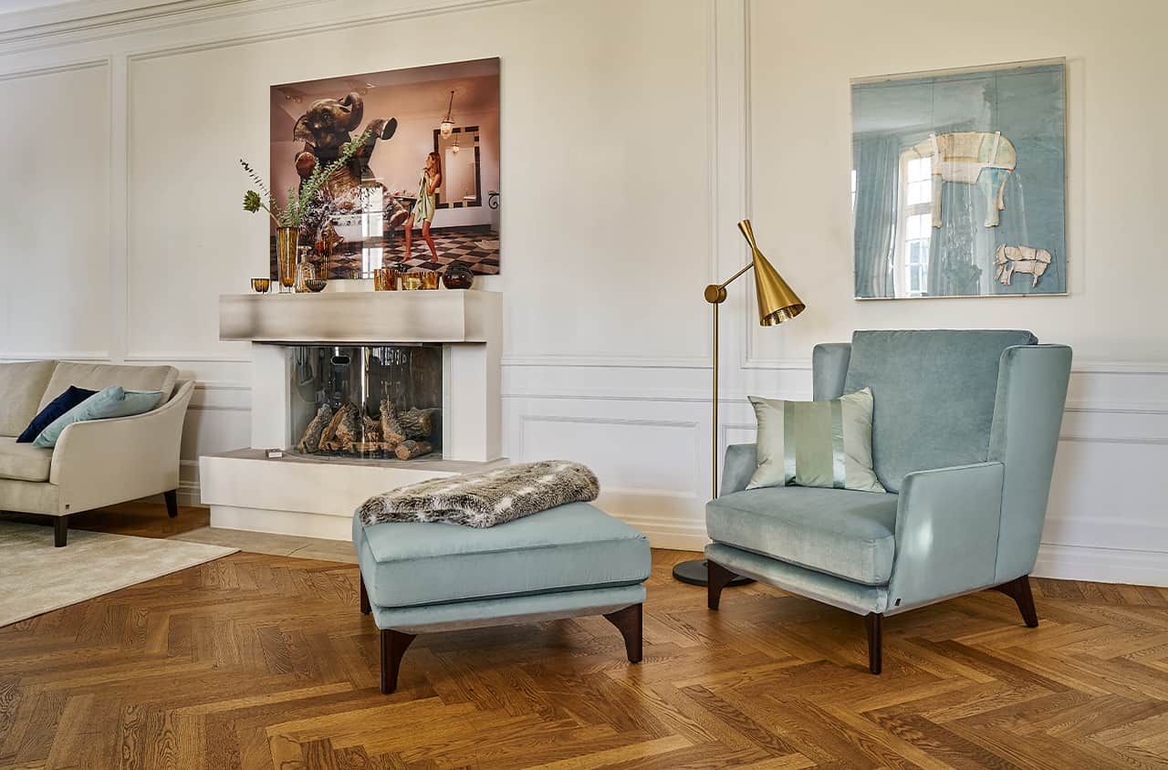 Sessel mit passendem Hocker in sanftem Blau, der Ruhe und stilvollen Komfort in den Raum bringt.